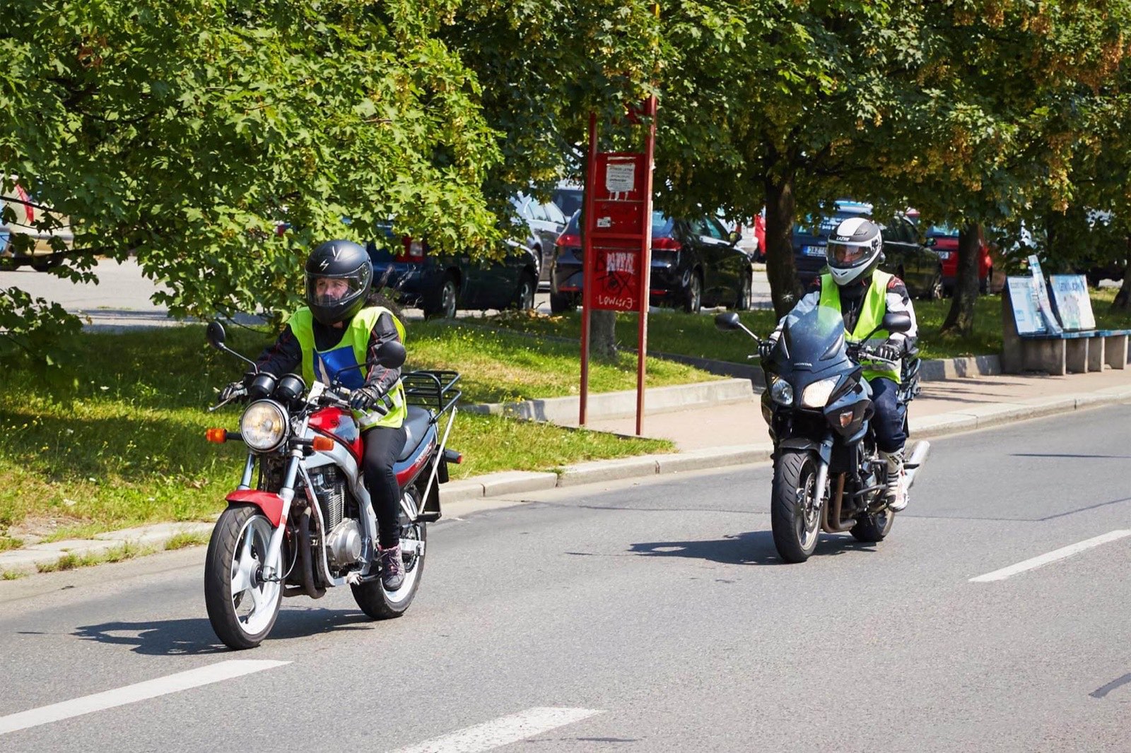 Žáci autoškoly na motorkách v provozu s instruktorem