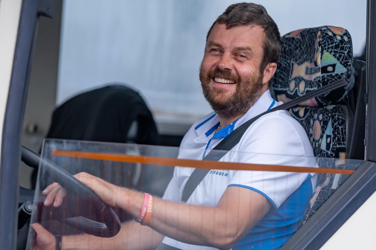 Usměvavý instruktor za volantem výcvikového autobusu
